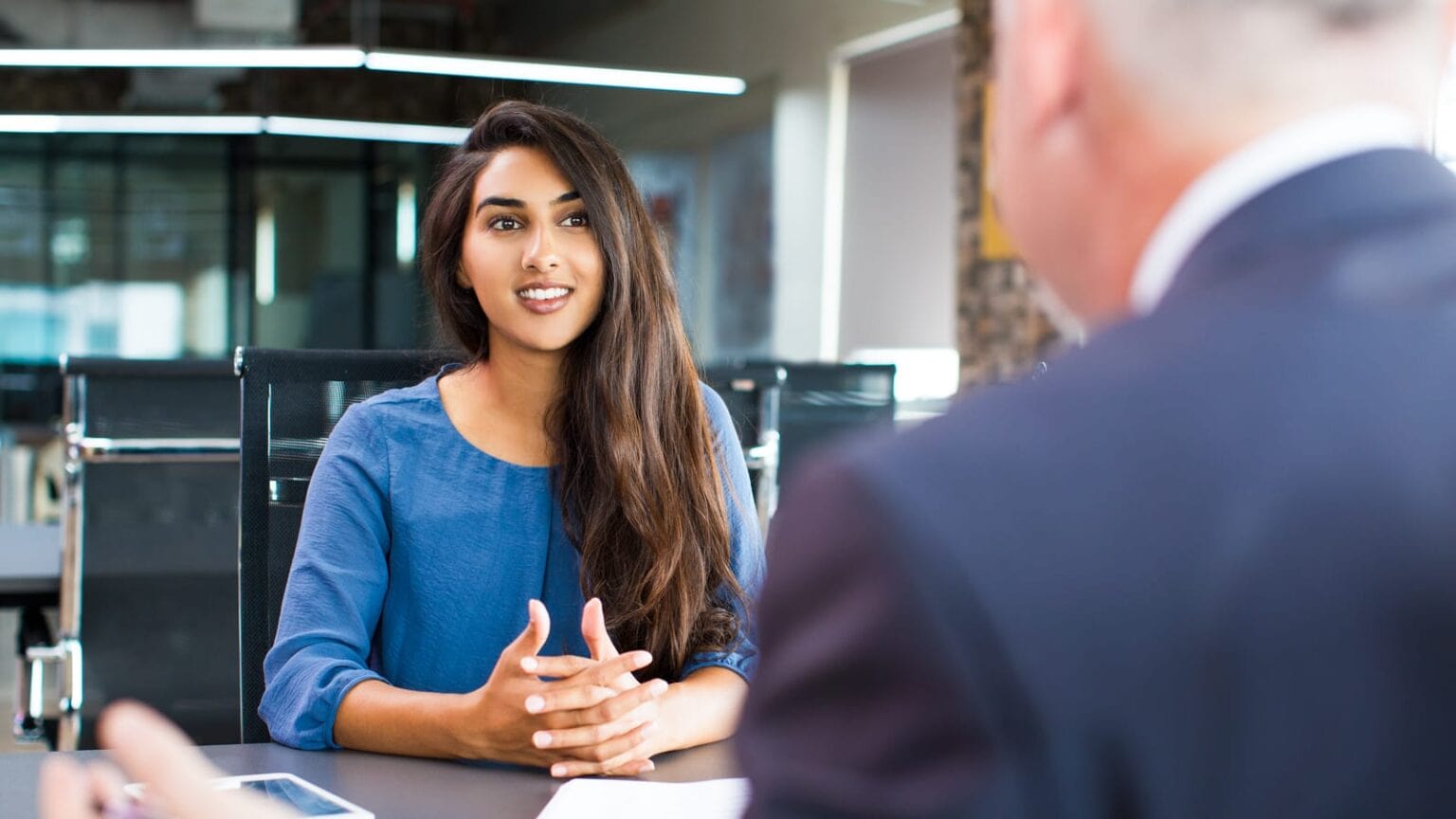 Empowered woman engaging in a professional development conversation at Five Lens People Development.